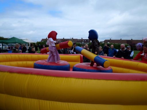 Two children battling on an inflatable gladiator joust